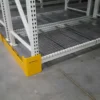 Warehouse racking with yellow safety guards.