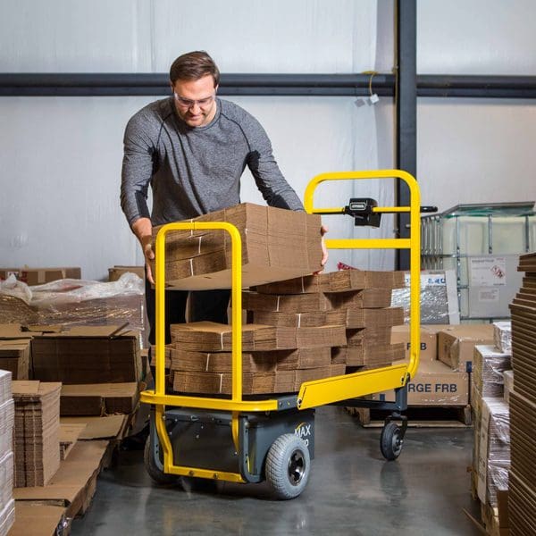 Man stacking boxes on a yellow cart.