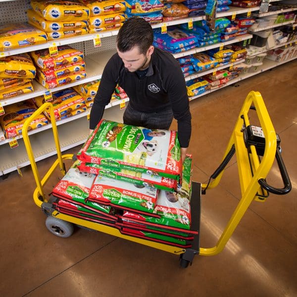 Man pushing cart with dog food bags.